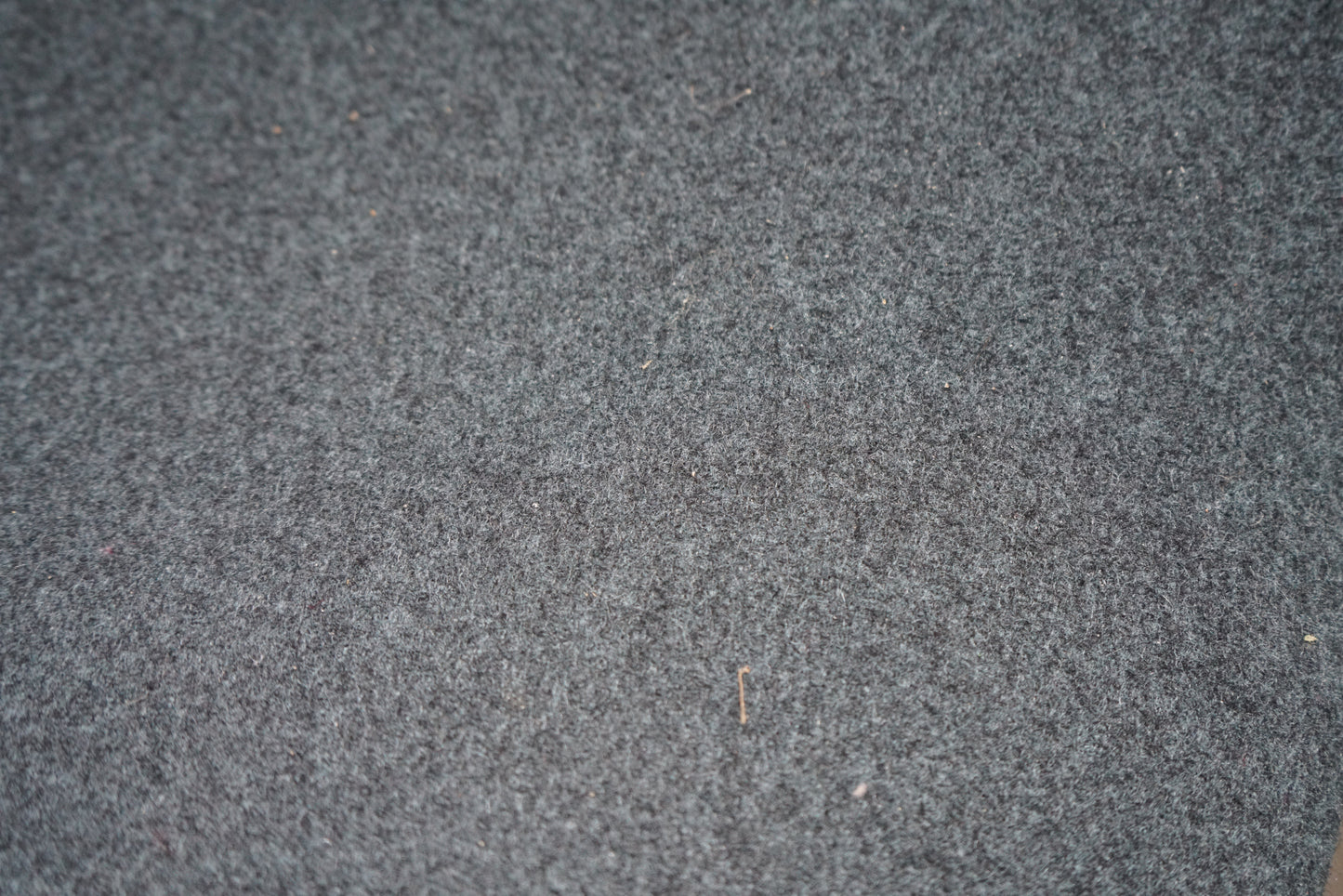 Close-up af blå uldpolstring på Offecct loungestol med stilrent krom stel.