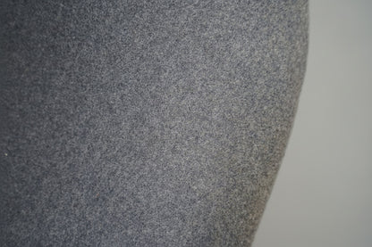 Close-up af lysegrå uldpolstring på Offecct loungestol med elegante detaljer og krom stel.