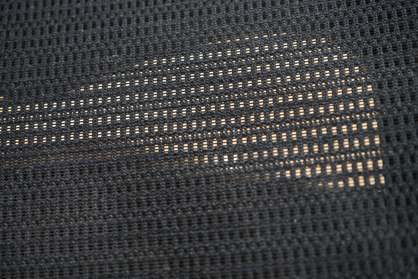 Close-up af Okamura Baron kontorstol med armlæn, der viser mesh-ryg og sædedetaljer.