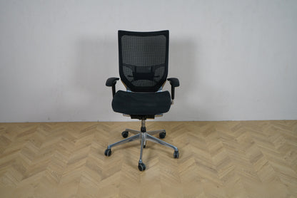 Okamura Baron kontorstol med armlæn set forfra, med sort mesh-ryg og krom fodkryds.