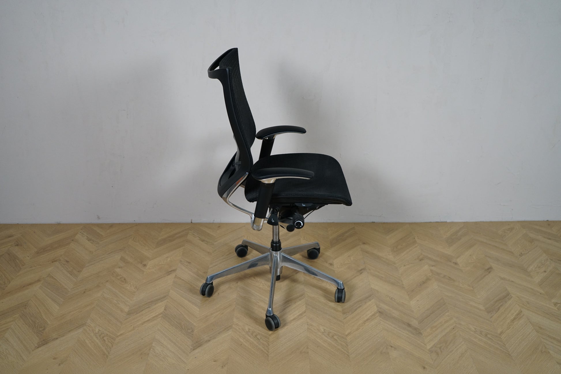 Okamura Baron kontorstol med armlæn set fra siden, med ergonomisk mesh-ryg og krom stel.