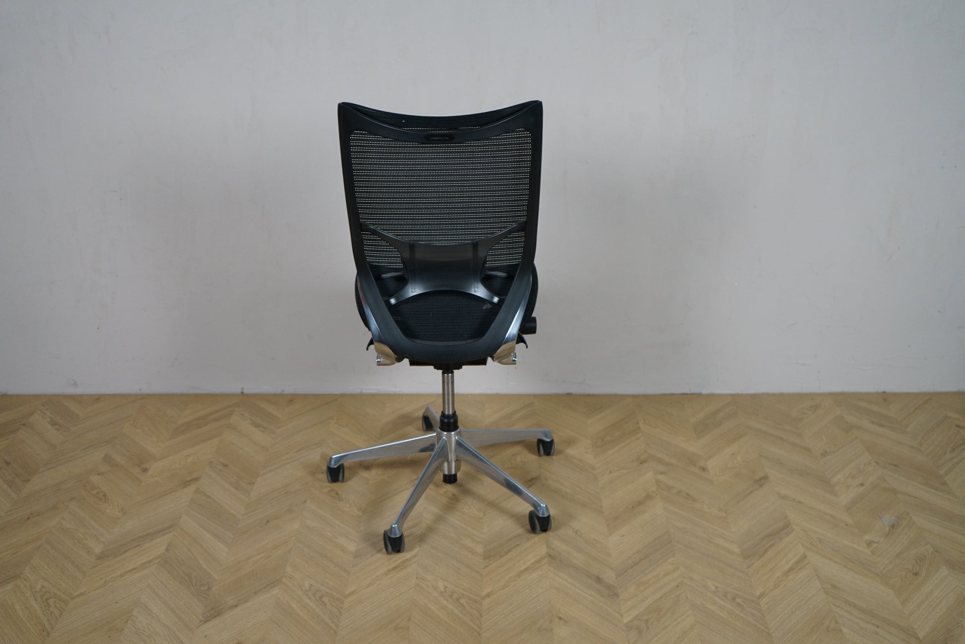 Okamura Baron kontorstol uden armlæn set bagfra, med sort mesh-ryg og krom fodkryds.