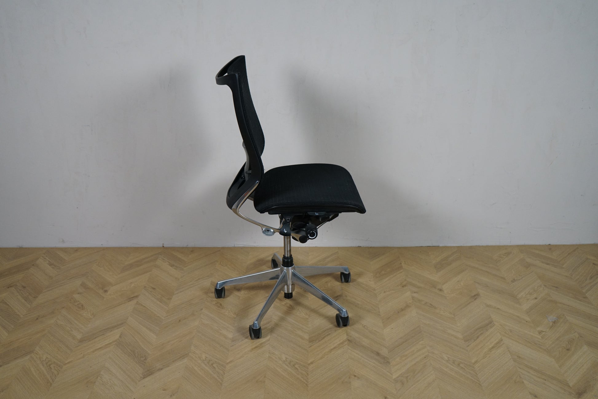 Okamura Baron kontorstol uden armlæn set fra siden, med ergonomisk mesh-ryg og krom stel.