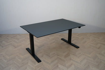 Paustian hæve-sænkebord 140x90 cm med sort linoleum og sort stel set fra skrå vinkel.