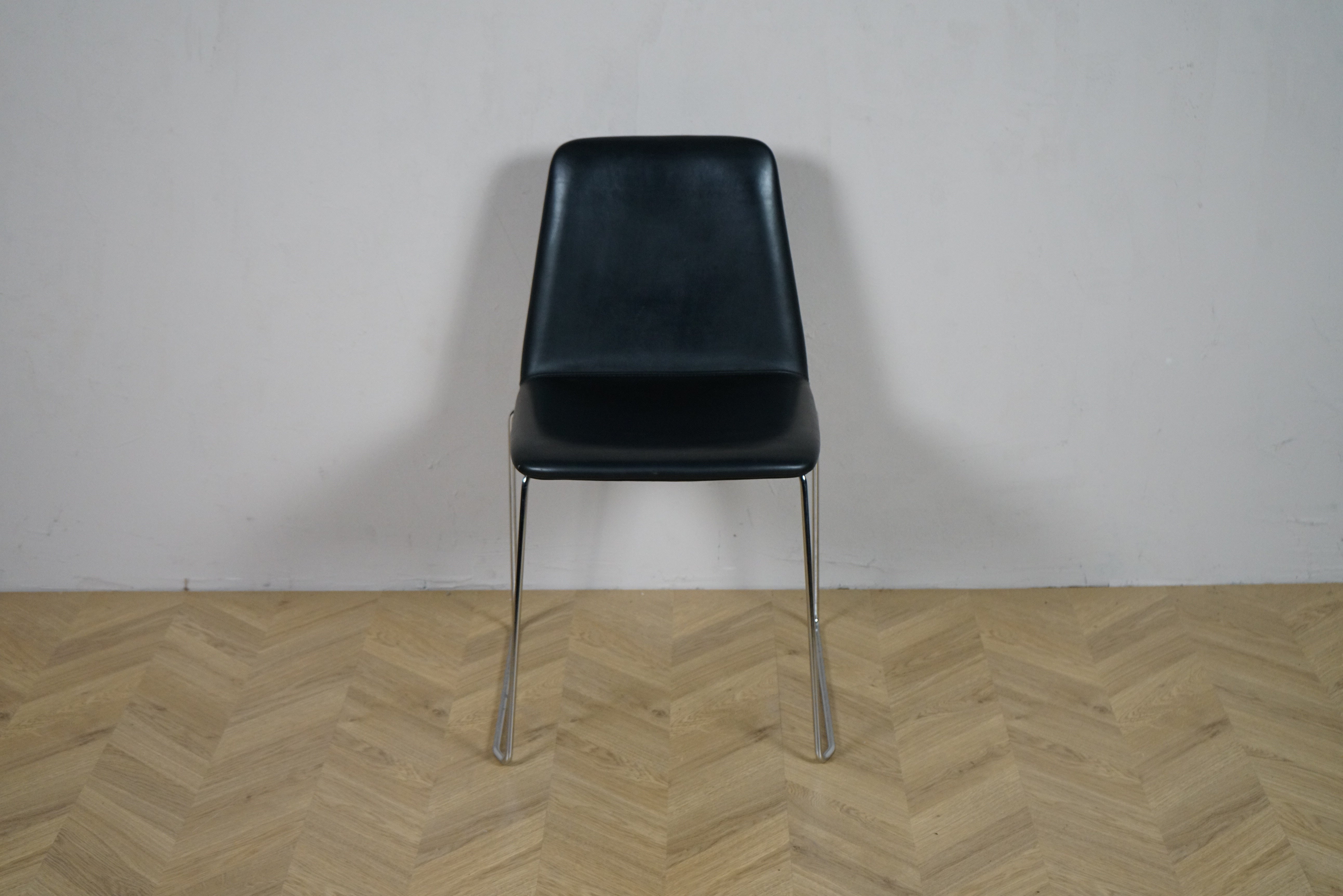 Paustian Spinal 44 konferencestol i sort læder set forfra med krom stel og elegant design.