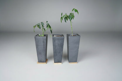 Tre matte antracit plantekasser med hjul set forfra