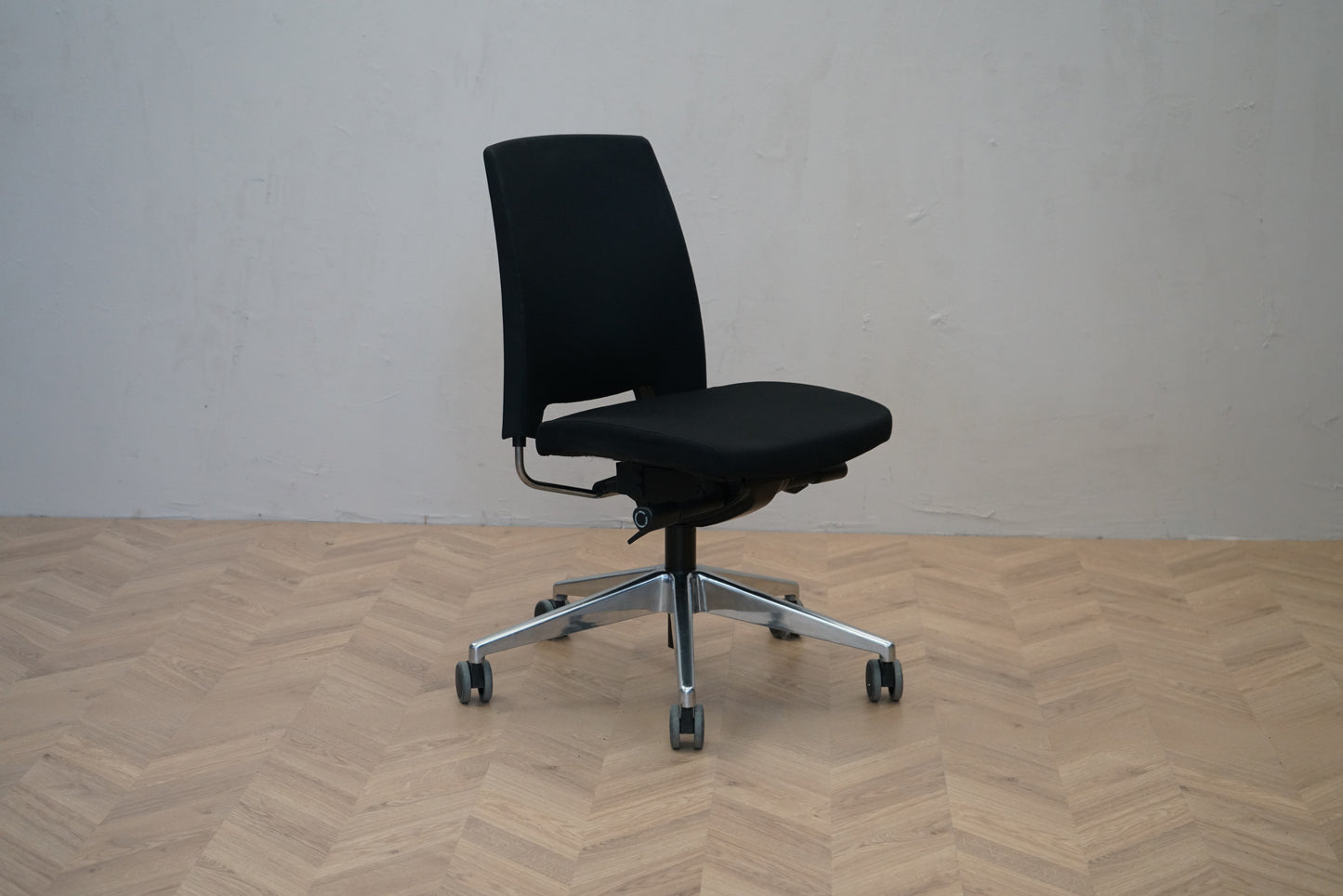 Profim kontorstol i sort set skråt med ergonomisk ryglæn og stål fodkryds