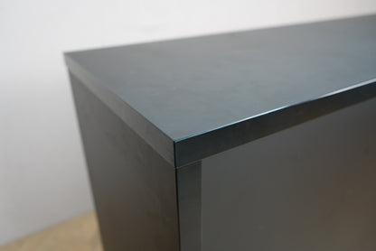 Detalje af sort laminatoverflade og aluminiumsplade på receptionsdisk.