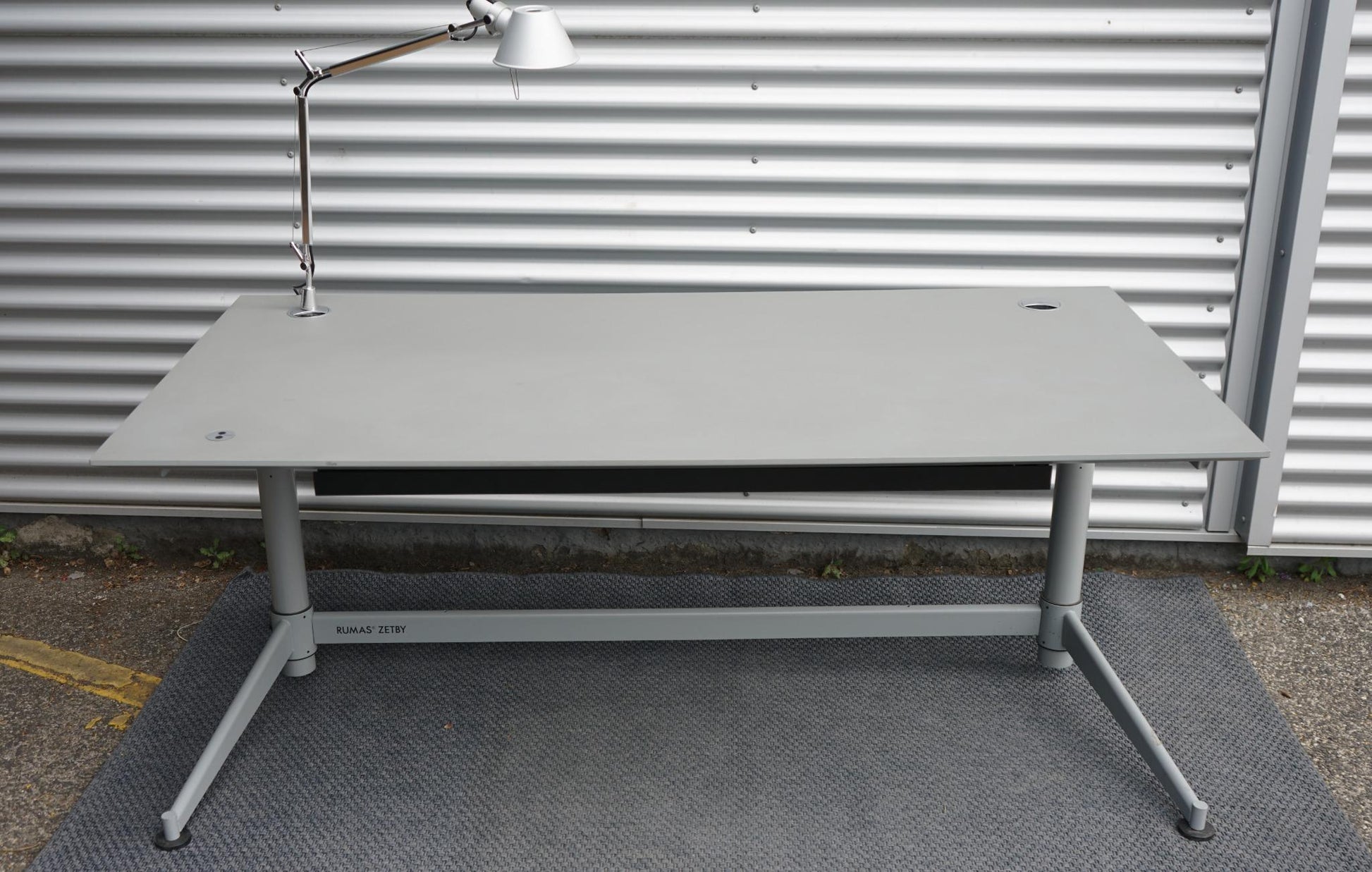 Frontvisning af Rumas Zetby hæve-/sænkebord 180x90 cm i grå med integreret kabelkanal og udtræksskuffe