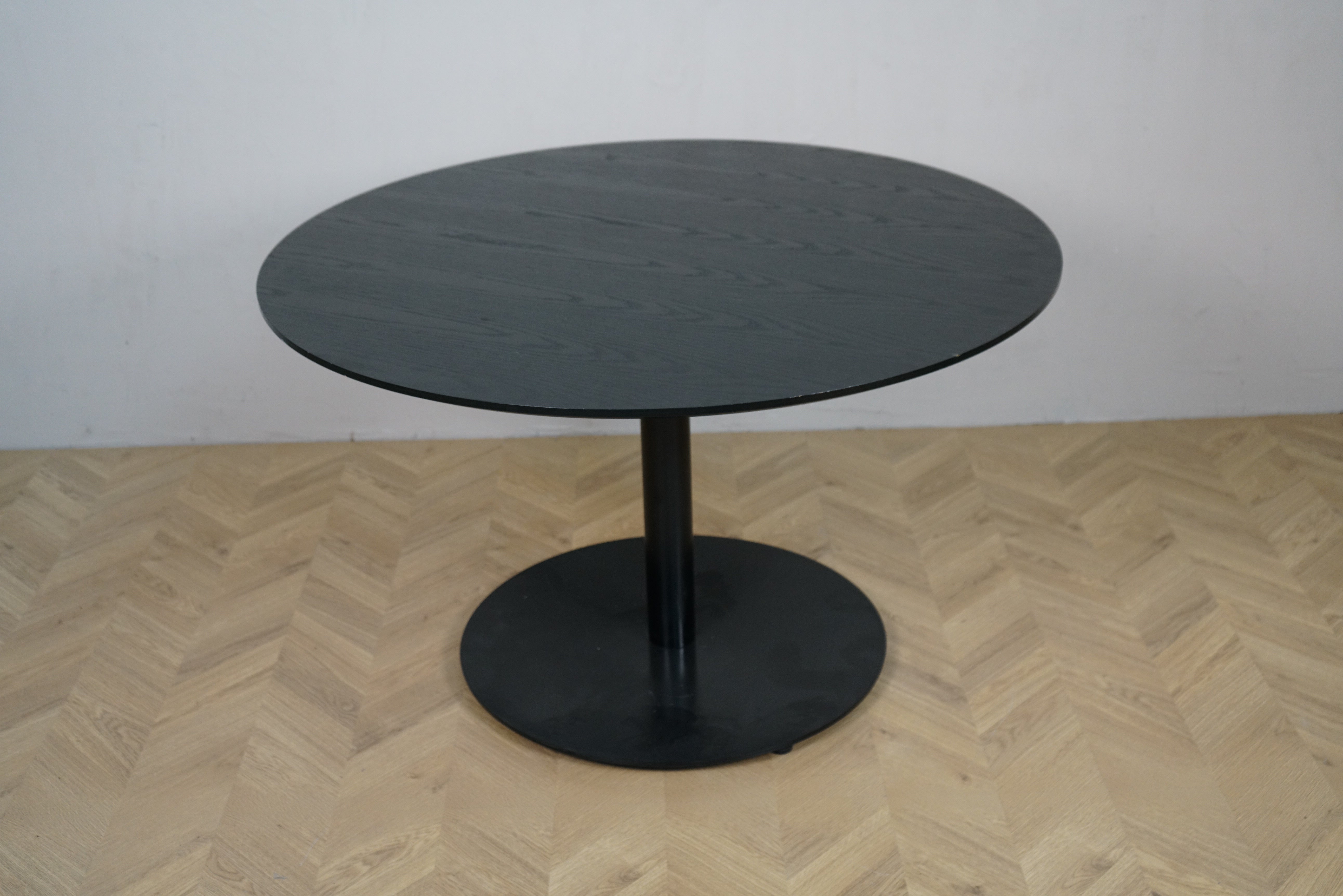 Rundt cafebord i sortbejdset eg med rund sokkel, set forfra