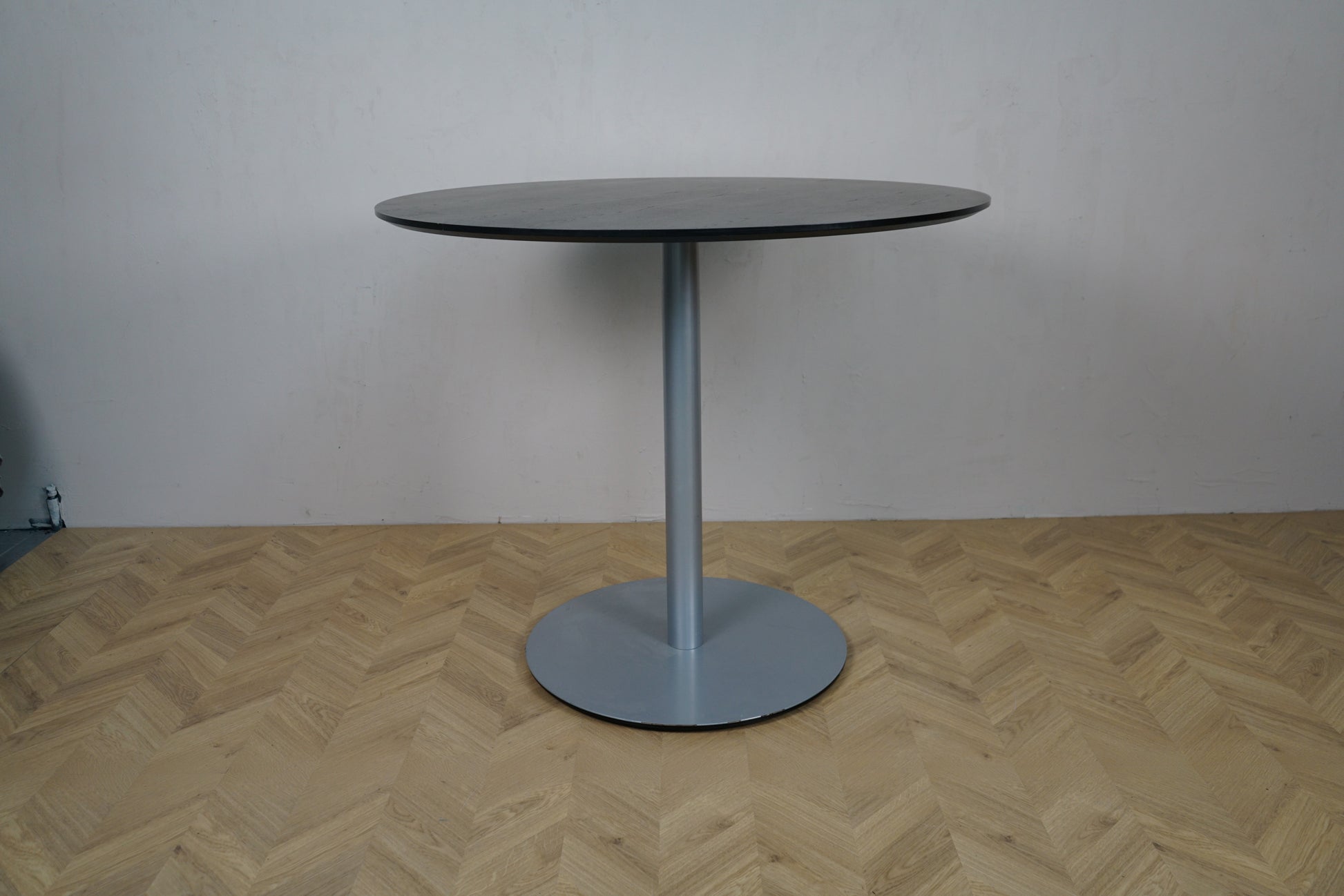 Sort rundt cafébord Ø120 med gråt metalstel, set fra siden