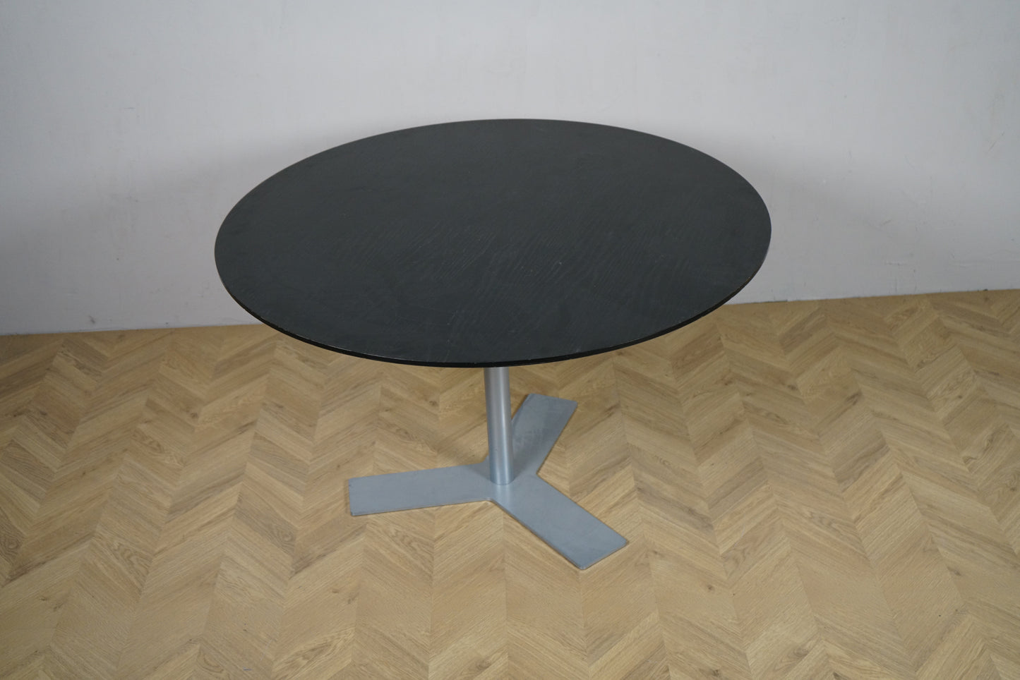 Rund sortbejdset egetræsplade Ø120 på gråt stel, set ovenfra