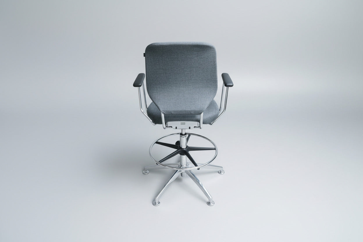 Savo kontorstol i grå polstring set bagfra med krom stel, fodstøtte og drejefunktion.