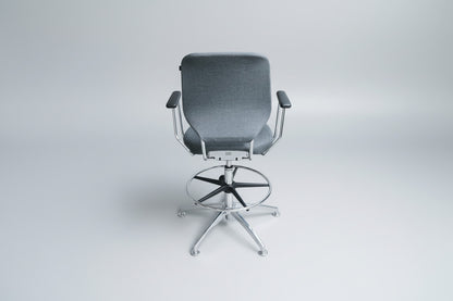 Savo kontorstol i grå polstring set bagfra med krom stel, fodstøtte og drejefunktion.