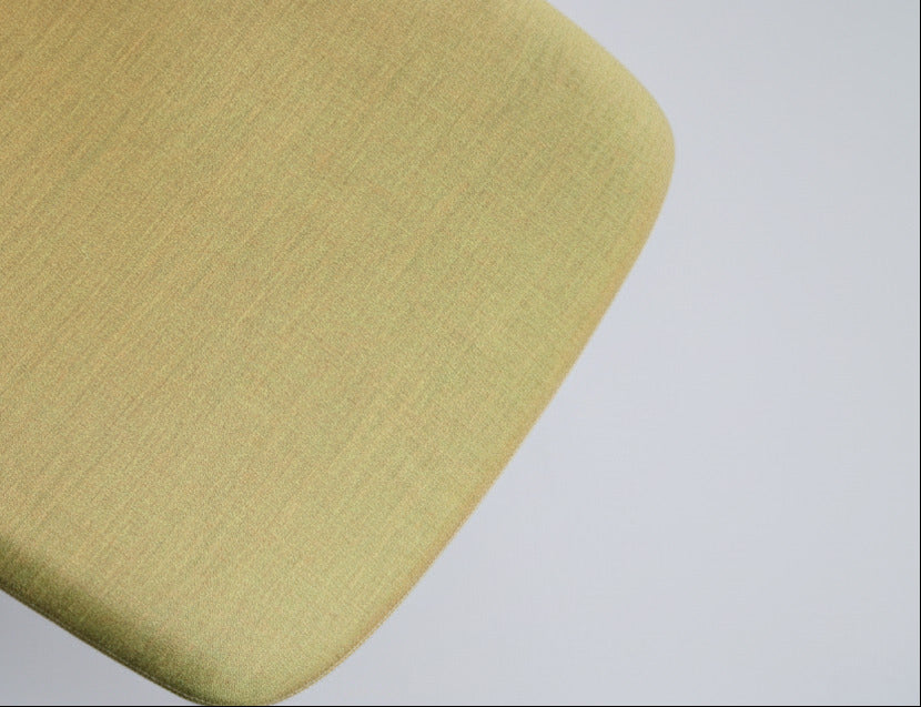 Close-up af gul polstring og detaljer på Savo kontorstol med krom stel og fodstøtte.