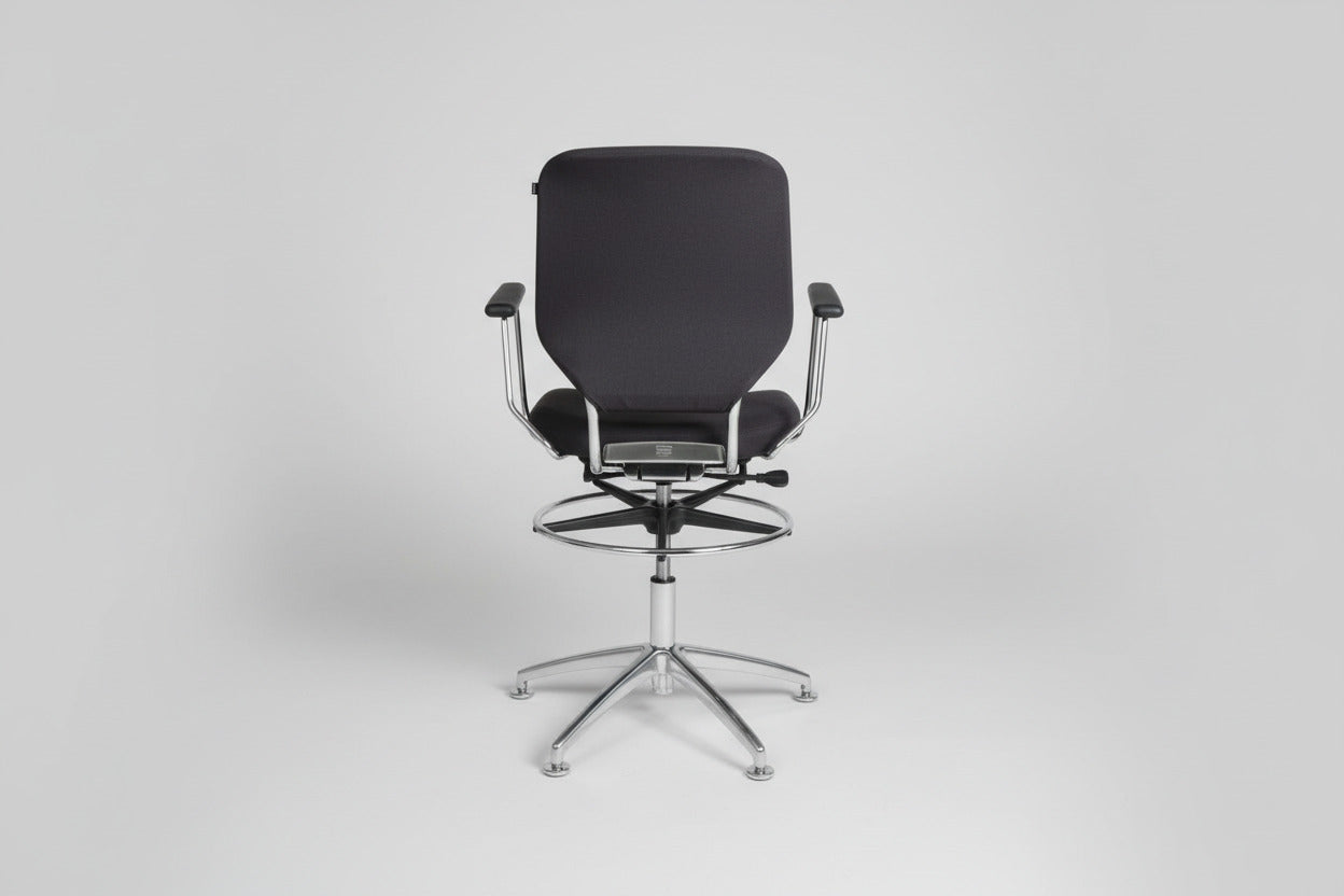 Savo kontorstol i mørkeblå polstring set bagfra med krom stel, fodstøtte og drejefunktion.