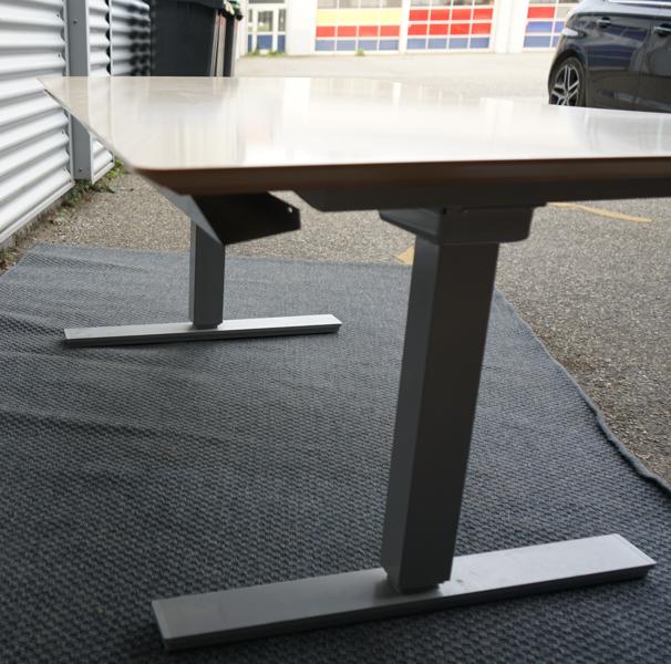 Detaljebillede af ben og gråt understel på Scanoffice hæve-sænkebord 160x90 i birkefiner med mavebue.