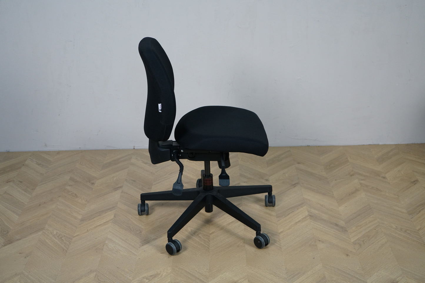 Scanoffice sort kontorstol set fra siden med ergonomisk ryglæn og justeringshåndtag.