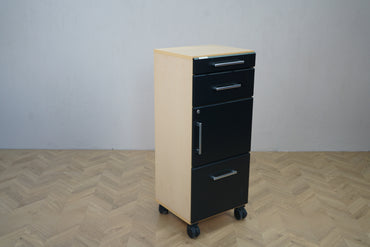 Smalt opbevaringsskab med skuffer, låge og hjul – set fra skrå vinkel, 46x38x111 cm