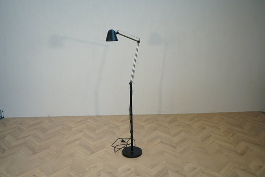 Sort gulvlampe med justerbar arm og lampeskærm set forfra.