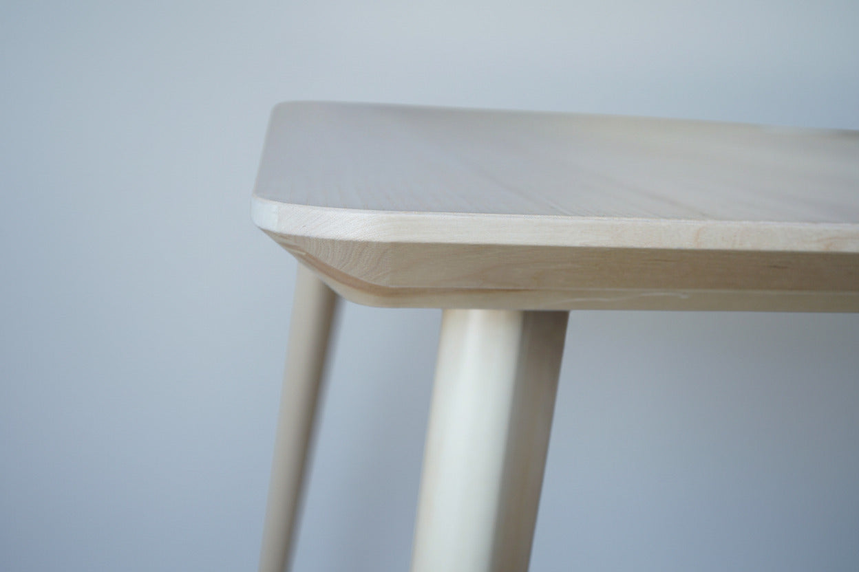 Close-up af affaset kant på spisebord i asketræsfiner med elegant finish