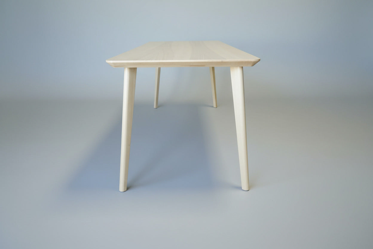 Spisebord i asketræsfiner set fra siden – harmonisk bordplade og ben