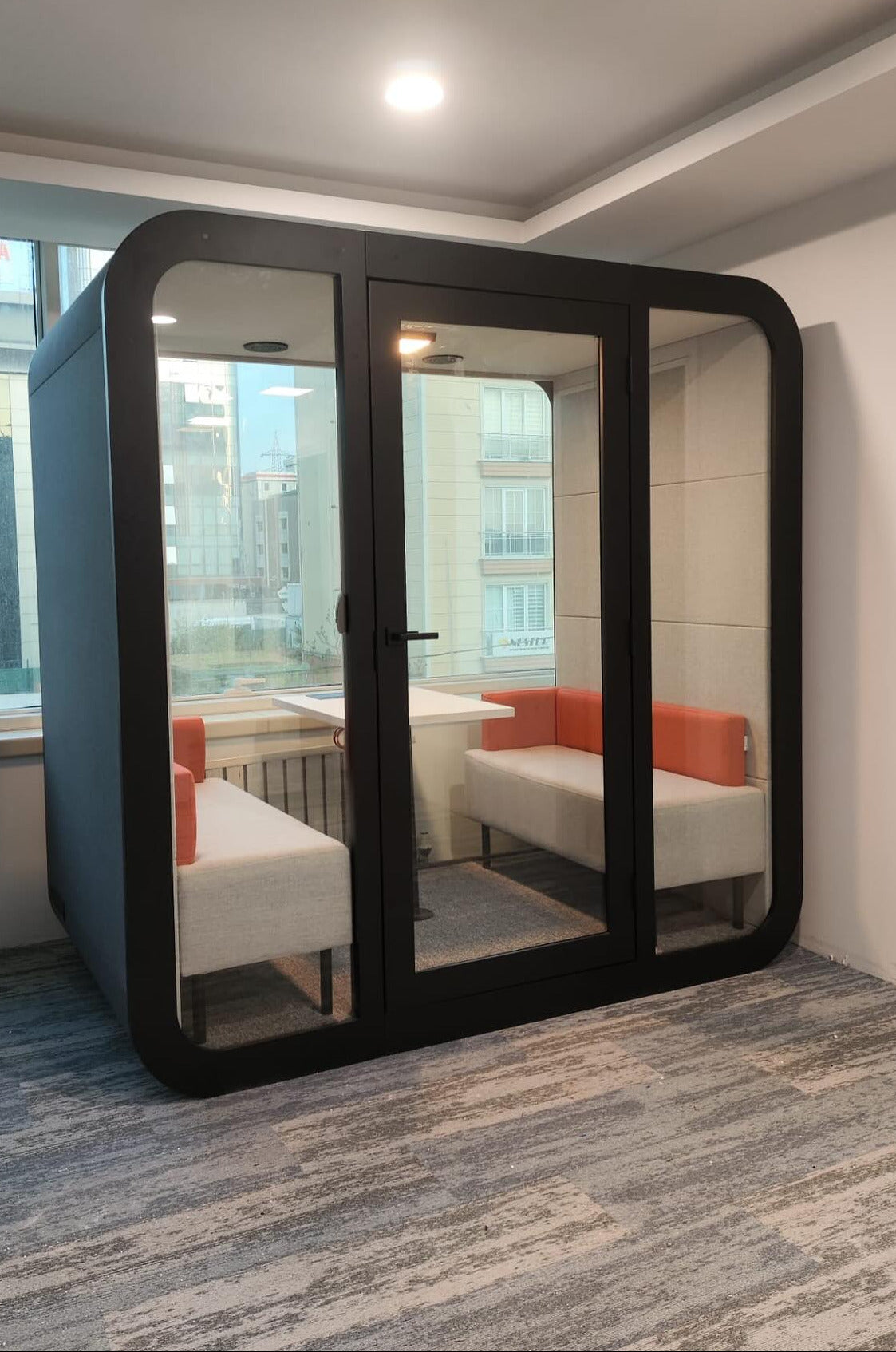 Stillbox kontorpod til 4 personer i sort set fra siden – lydisoleret kontorpod med moderne design, dobbelt glas og effektiv ventilation til møder, videokonferencer og fokuseret arbejde.