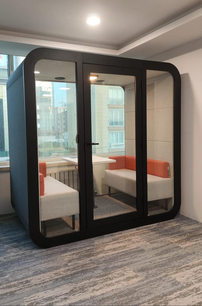 Stillbox kontorpod til 4 personer i sort set fra siden – lydisoleret kontorpod med moderne design, dobbelt glas og effektiv ventilation til møder, videokonferencer og fokuseret arbejde.