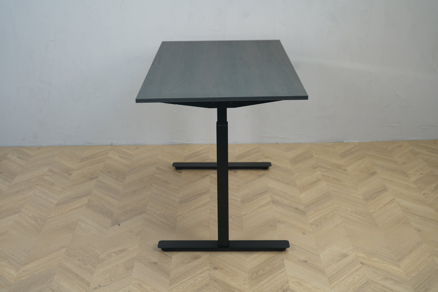 Sweds hæve-sænkebord 120x70 cm i mørk egetræ – set fra siden med sort stel