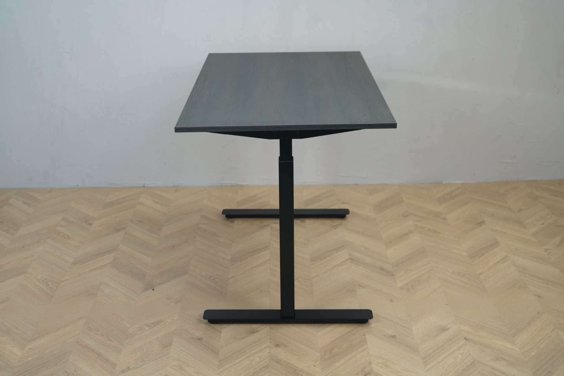 Sweds hæve-sænkebord 120x70 cm i mørk egetræ – set fra siden med sort stel