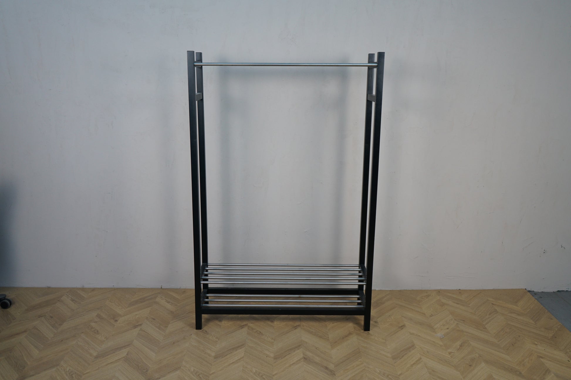 Sort tøjstativ i metal med bøjlestang set forfra