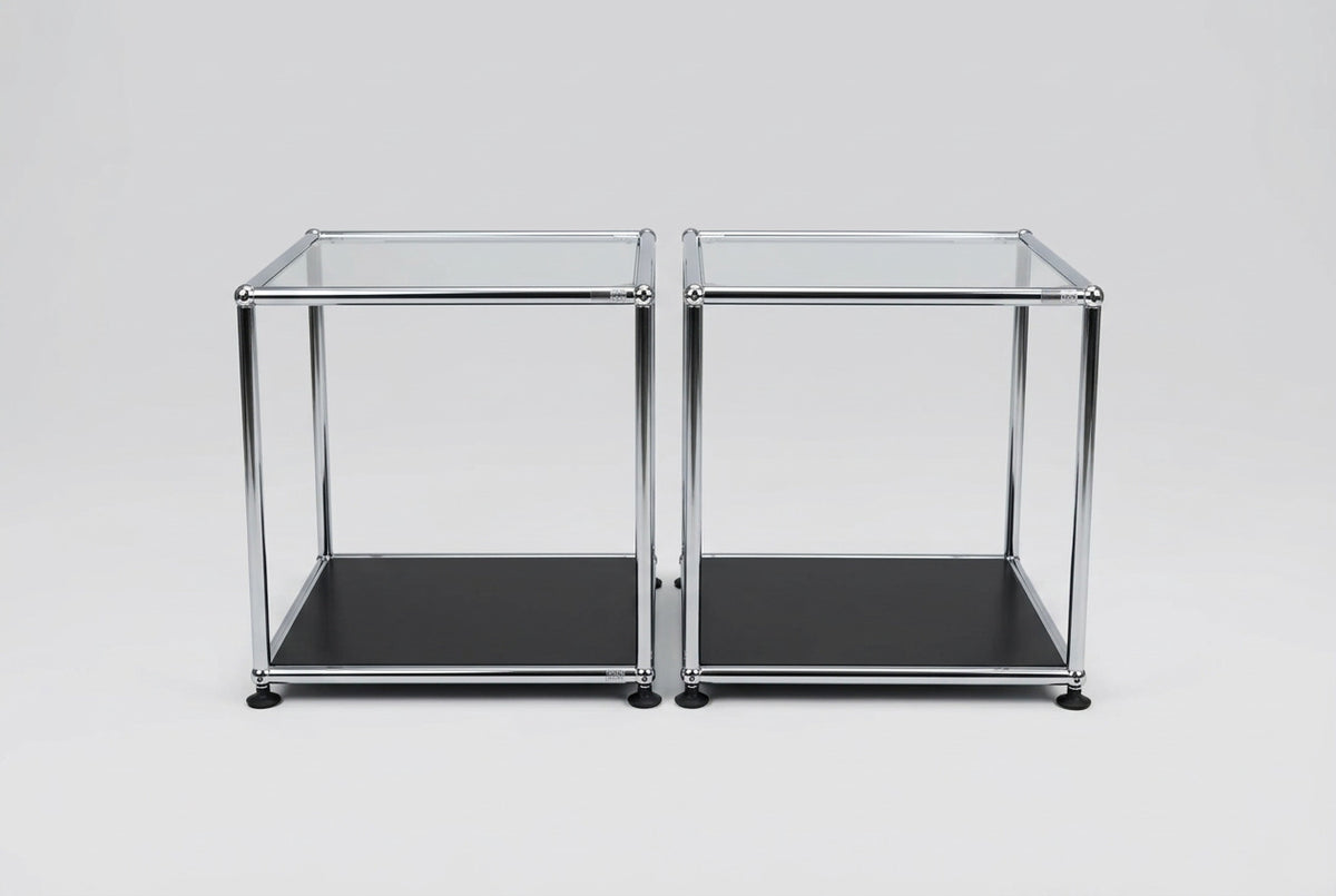 To USM Haller designer sideborde i glas med kromstel og sort bundhylde, 40x40x44 cm, set forfra.