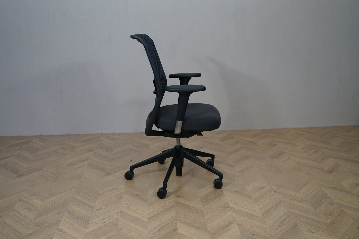 Sidevisning af Vitra ID Mesh kontorstol med mesh ryg, armlæn og hjul