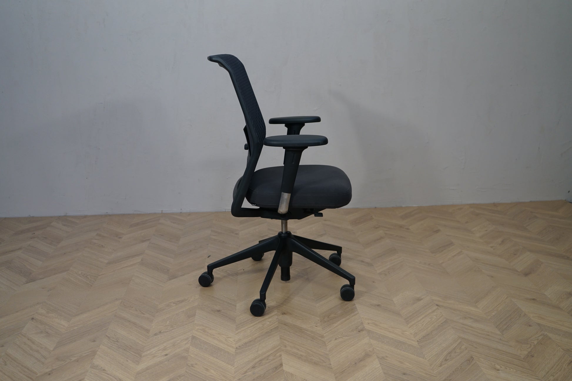 Sidevisning af Vitra ID Mesh kontorstol med mesh ryg, armlæn og hjul