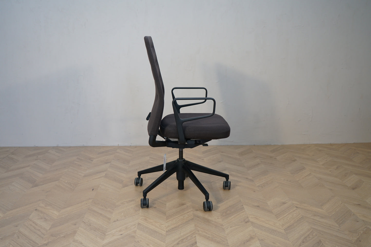Vitra ID Trim ergonomisk kontorstol i mørkegrå set fra siden med sort stel.
