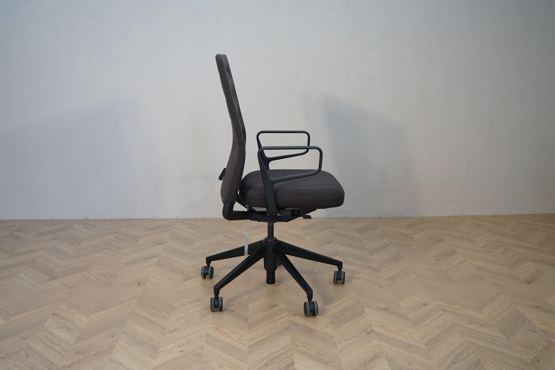Vitra ID Trim ergonomisk kontorstol i mørkegrå set fra siden med sort stel.