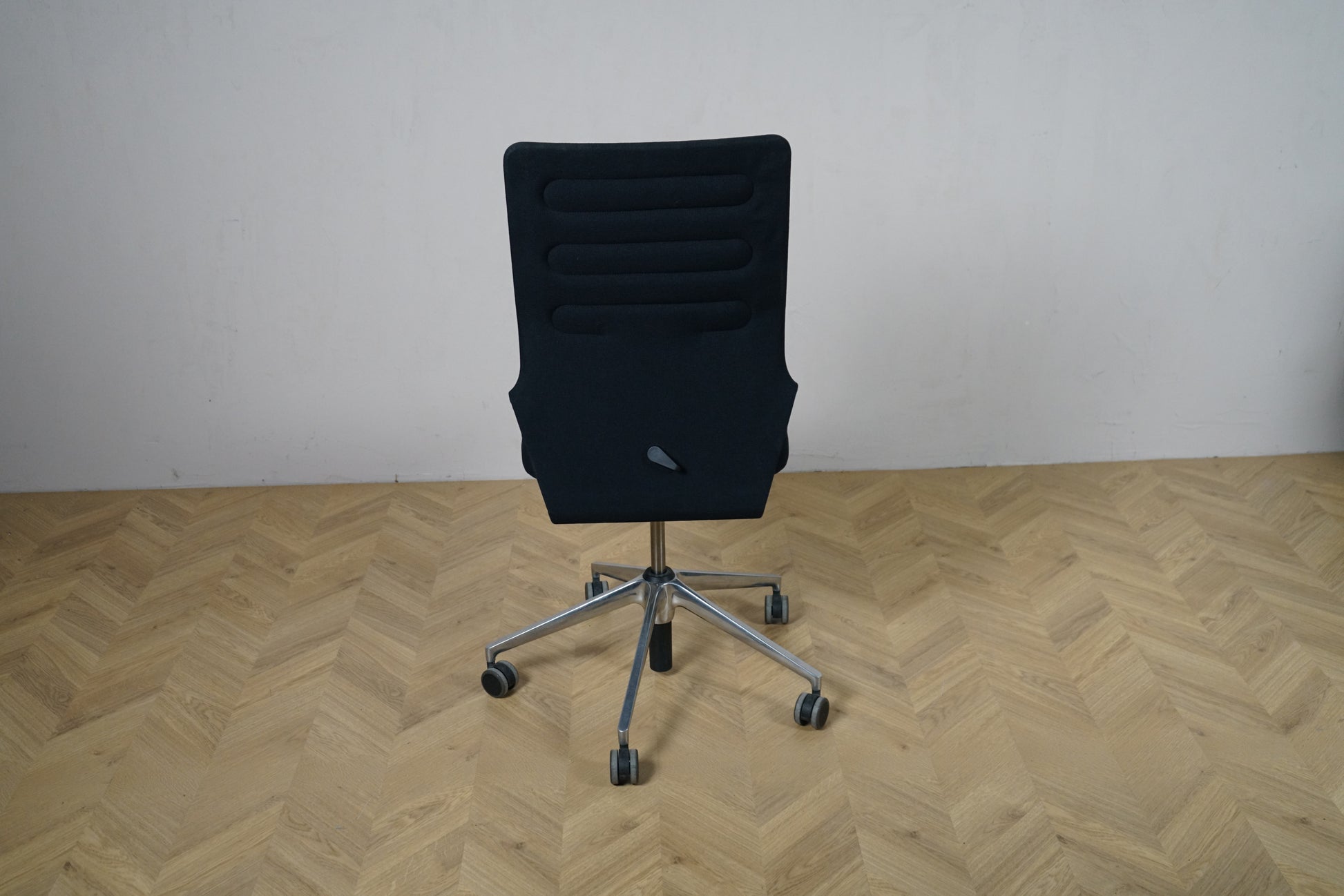 Vitra ID Trim kontorstol set bagfra med sort polstret ryglæn og slank ergonomisk design. Robust og velplejet kontorstol til kontorbrug.