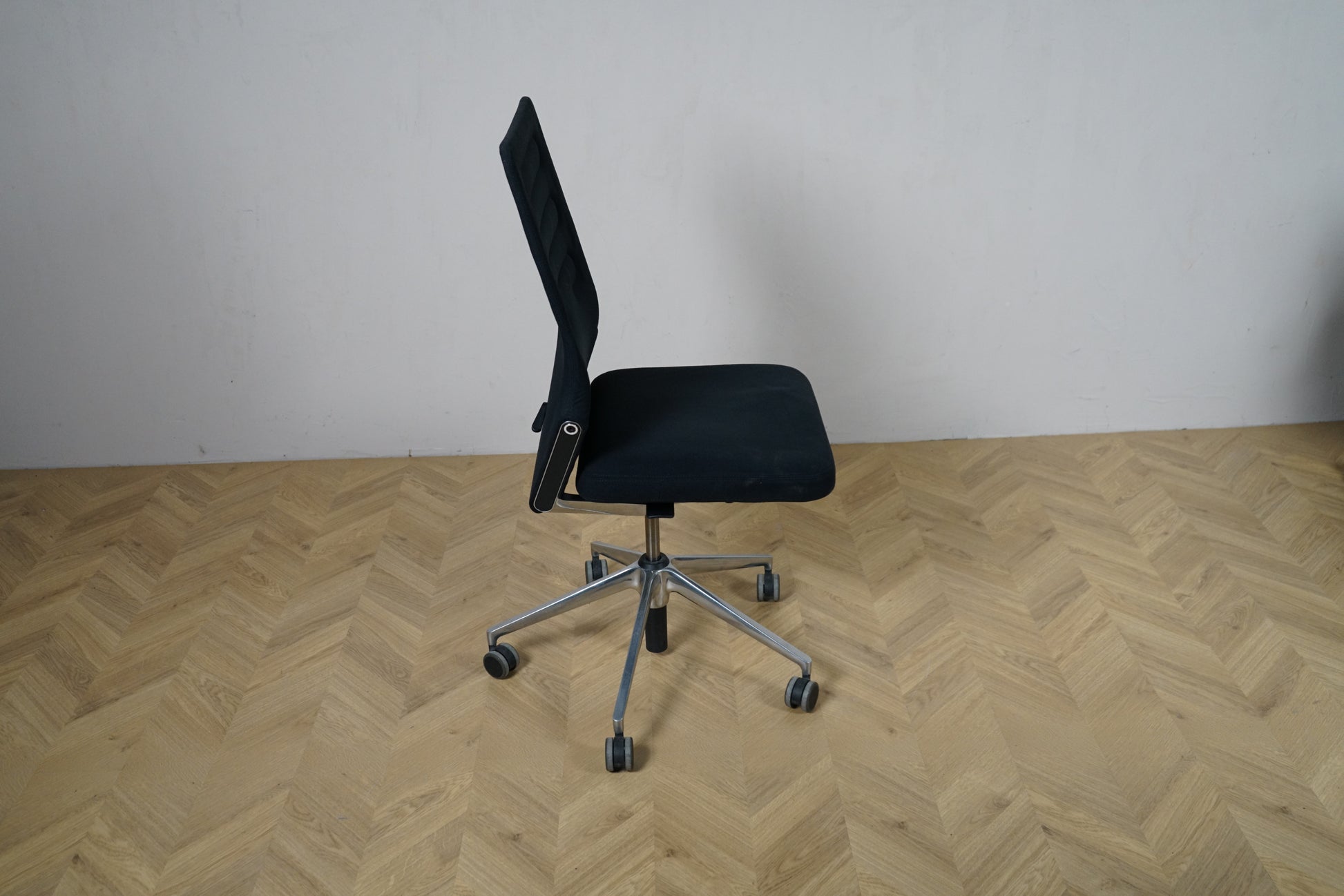 Vitra ID Trim kontorstol fotograferet fra siden, der viser den ergonomiske ryglænsvinkel og sort polstring. Brugt men velholdt kontorstol i premium kvalitet.