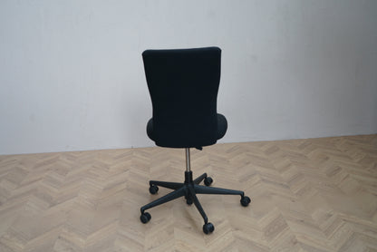 Bagfra visning af Vitra ID Trim kontorstol i sort uden armlæn med solid konstruktion og polstret ryglæn.