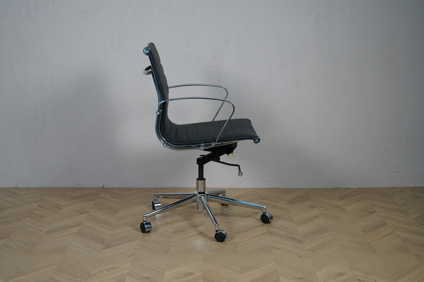 Wye kontorstol i sort læder med lav ryg og krom armlæn – sidevisning