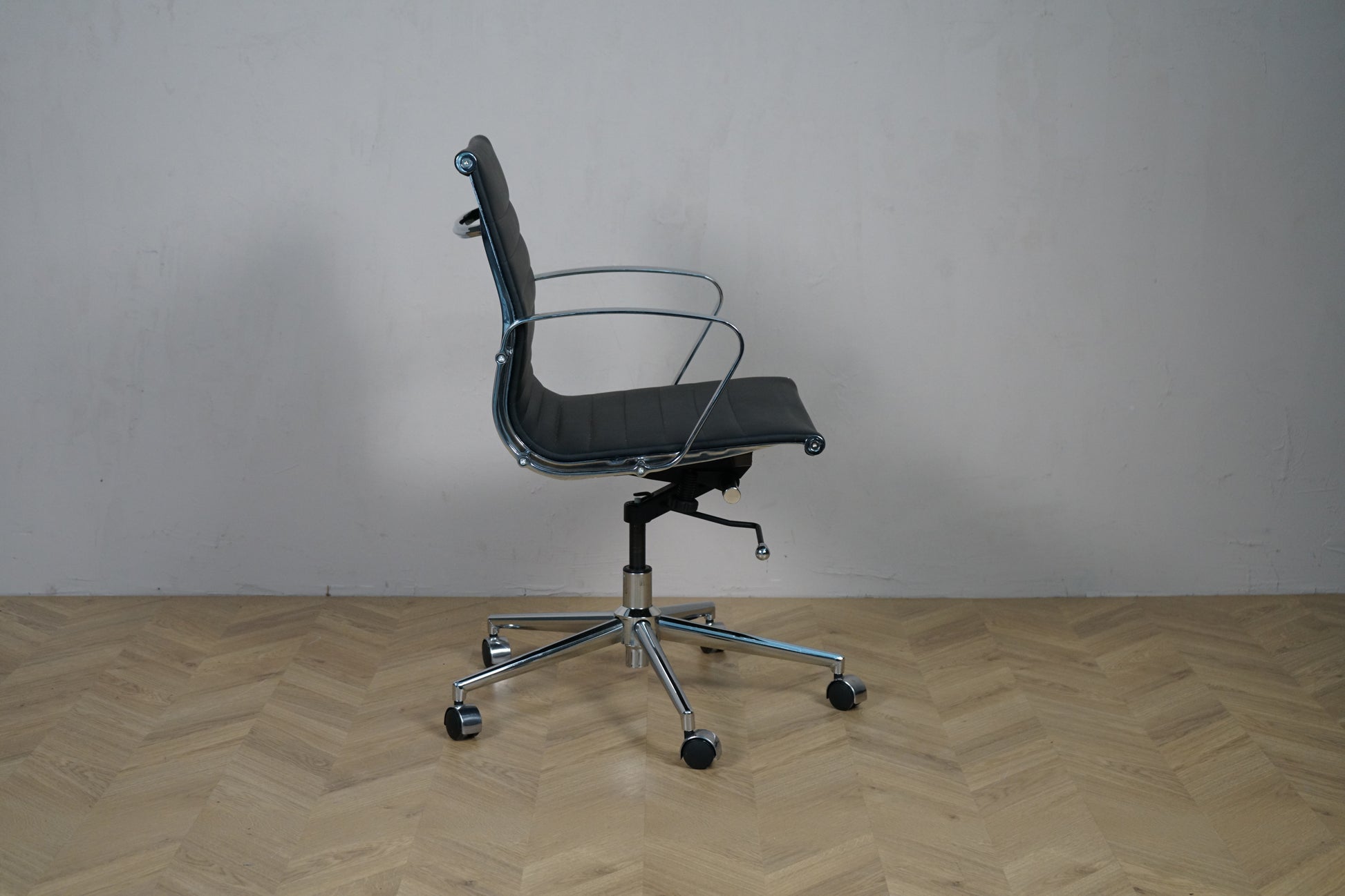 Wye kontorstol i sort læder med lav ryg og krom armlæn – sidevisning